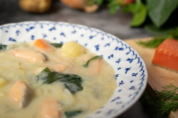 テーブルに置かれた鮭とほうれん草のクリームシチューとその材料