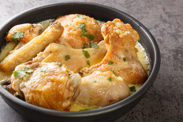 Shkmeruli is a traditional Caucasian Georgian dish of chicken in garlic sauce closeup in the pot on the table. Horizontal