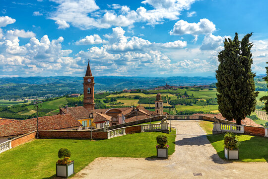 Town of Govone overlooking green hills under beautiful sky in Italy.