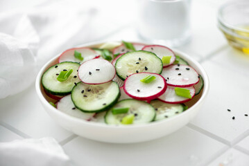 vegetable salad of cucumbers and radishes with olive oil, close-up