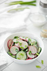 vegetable salad of cucumbers and radishes with sour cream and sesame