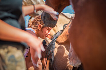 A young beautiful girl works on a horse farm.