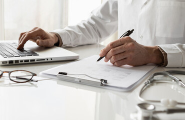 Closeup of doctor medical professional wearing uniform taking notes, physician, therapist or practitioner filling medical documents, writing prescription for patient. Health care, medicine concept