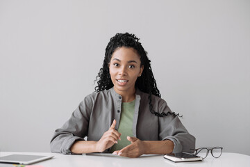 Beautiful young woman looking and speaking through the web camera while making a video conference...