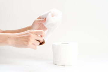 Hand and toilet paper on white background.