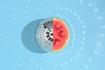 Creative concept of a summer fruit festival. Mirror ball of watermelon on a blue background with...