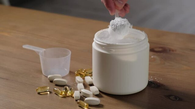 A man shows creatine or amino acids in a measuring spoon, close-up
