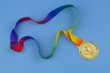 Gold medal with colorful ribbon on blue background