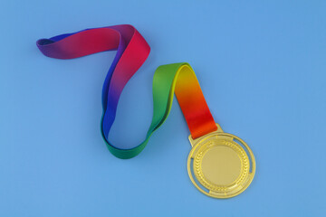 Gold medal with colorful ribbon on blue background