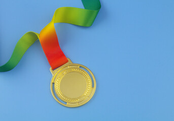 Gold medal with colorful ribbon on blue background