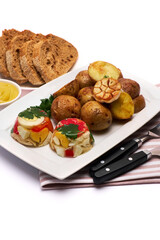 Portion of delicious chicken aspic and baked potato on a plate isolated on white background