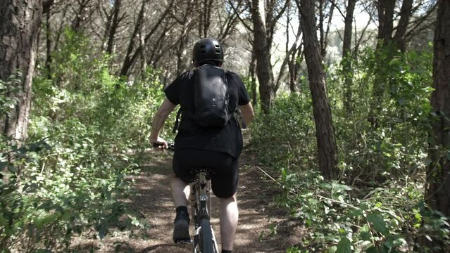 young man rides mountain bike in forest trail slow motion 4k