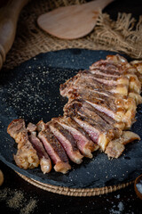 Ribeye steak medium rare slide on the graphite cutting bord