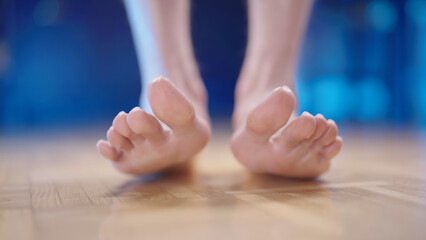 Person feet stand on heels with hallux valgus