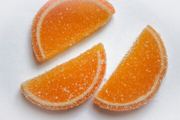 Yellow and orange marmalade in the form of lemon and orange candied slices isolated on white background.