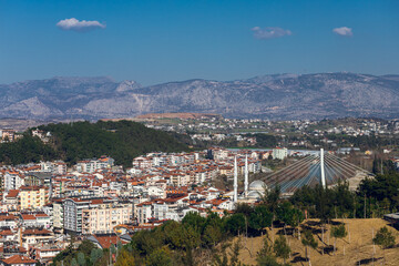 Residential area in a tropical country with many similar houses with water barrels basking in the sun, mountain at the background , soft focus