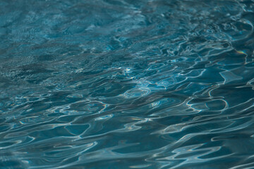 Close-up blue sea water. Abstract water background. The texture of the water waves of a large fountain