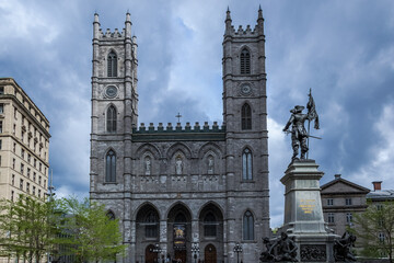 Architectural detail of the Place d'Armes in Montreal, Canada, with the Notre-Dame Basilica in the background and in the foreground the monument of Paul de Chomedey, founder of the city