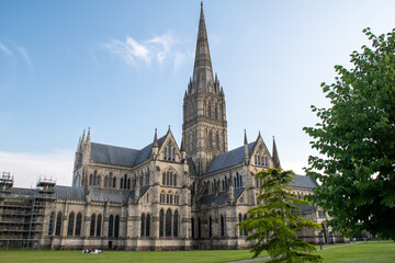 The spire of Salisbury Cathedral, Wiltshire, against a clear blue sky at golden hour. July 2021