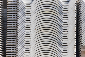 Close-up of white beach chairs stacked ergonomically on top of each other