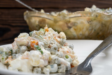 Russian traditional Olivier salad with vegetables and meat. Winter salad for New Year and Christmas. close-up, selective focus.