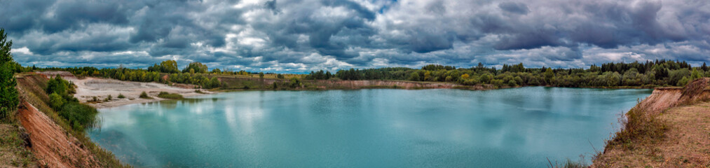Fototapeta na wymiar lake in the limestone quarry on a cloudy gloomy summer day