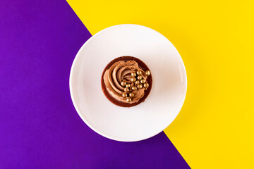 a cake on a white saucer on a colored background. holiday and party concept