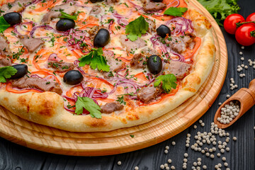 Delicious Italian pizza with meat, ham and vegetables