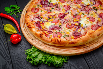 Pizza with quail eggs, ham, sausage and vegetables