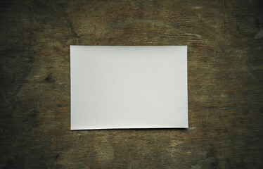 White rectangular sheet for the photo.A blank form for a photo on a wooden table. An empty old...