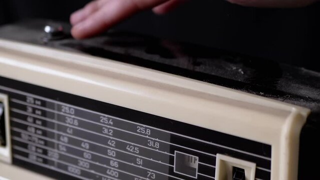 A Female Hand Wipes Dust From The Surface Of An Old Receiver With Her Finger. Disused Old Fashioned Vintage Retro Tape Recorder, 80s, 90s Period Radio Covered In Dust. Outdated Electronics, Player.