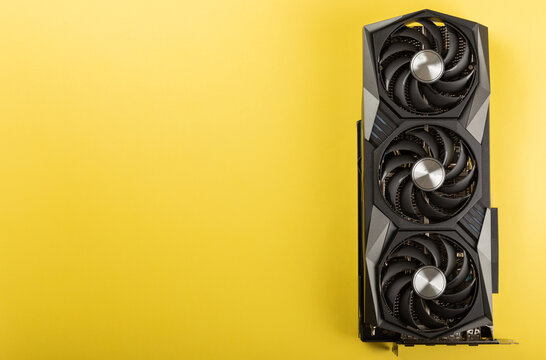 Game video card, video card adapter on a yellow background for video games and cryptocurrency mining. Computer parts. GPU card. copy space.