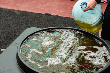 Soap solution for the holiday with soap bubbles close up, soap solution in a vessel for bubbles, a...
