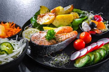 Fried salmon with potatoes and vegetable salads