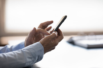 Side close up view old senior grandmother using smartphone software applications, web surfing useful information, enjoying playing mobile games, shopping in internet store, communicating online.