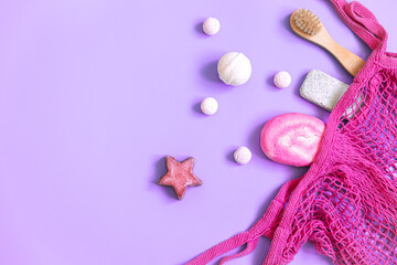 Spa composition with bath accessories in a pink string bag, flat lay.