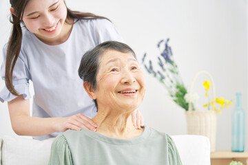 孫に肩もみされる祖母