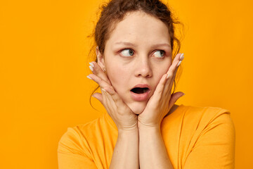 funny girl gestures with hands grimace emotions yellow background unaltered