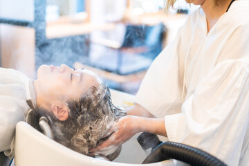ヘアサロンでスチームトリートメントを受ける女性
