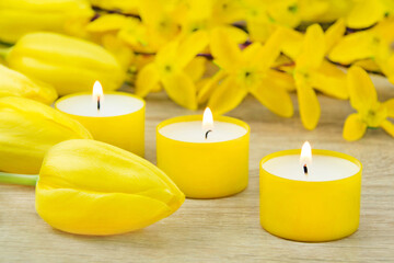 Fototapeta na wymiar Yellow decorations with candles and tulips closeup