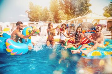 Group of friends in swimsuit enjoy in a swimming pool