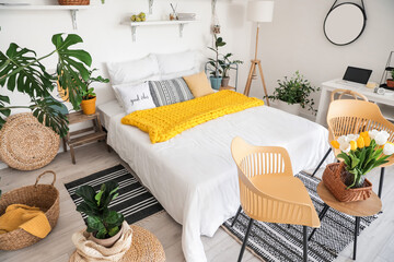 Stylish interior of modern bedroom with houseplants