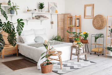 Stylish interior of modern bedroom with houseplants