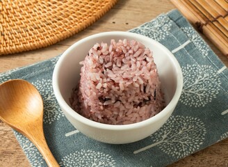Poor Charlie's Plain Purple Rice in a white bowl with wooden spoon isolated on mat top view