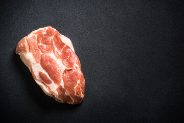 Raw meat. Fresh steak, pork steak at black background. Top view with copy space.