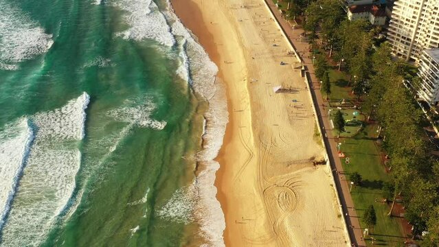 Sports and active beachgoers people on Manly beach in Sydney – aerial 4k.
