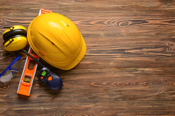 Safety equipment with builder's level and radio transmitter on wooden background