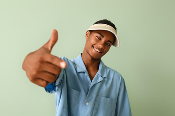 Handsome stylish African-American guy on color background