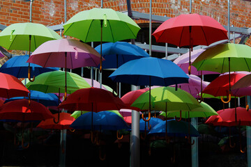 many colourful hanging umbrellas in artist arrangement giving shade from the sun