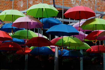 Fototapeta na wymiar many colourful hanging umbrellas in artist arrangement giving shade from the sun